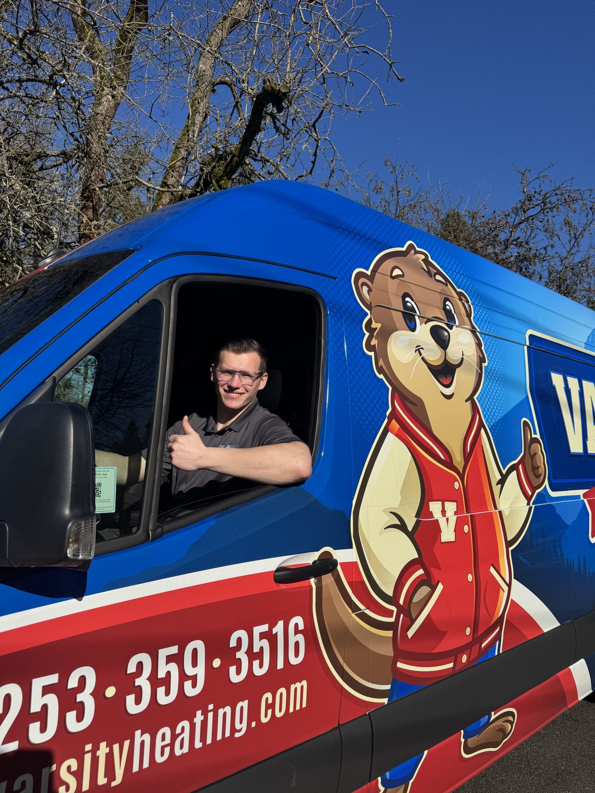 Vlad, Varsity co-owner, waving from the driver's seat of a Varsity van